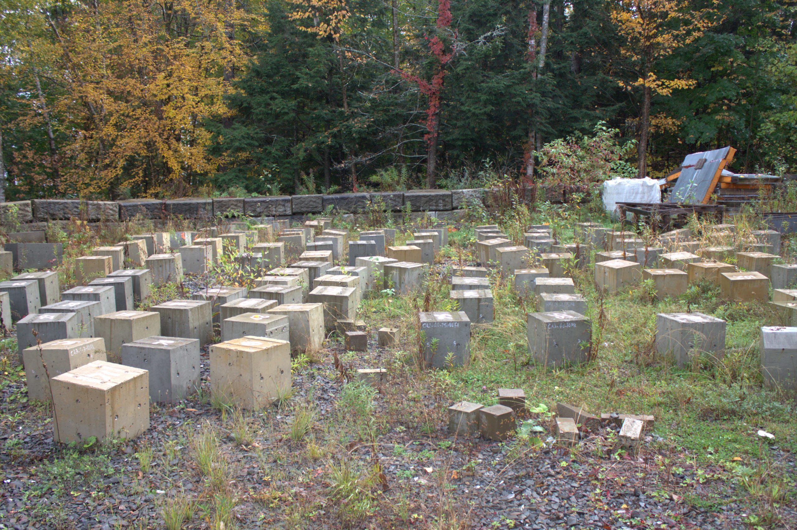 A gravel lot filled with concrete cubes being used for research purposes.