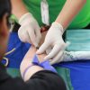 A nurse takes blood from a patients arm.